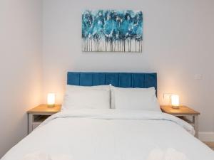 une chambre avec un grand lit avec deux lampes sur des tables dans l'établissement Brand-New Trendy 2BR in the Vibrant Town Centre - Pass the Keys, à Reading