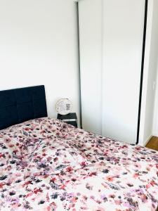 een slaapkamer met een groot bed met een sprei met bloemen bij Cosy chez FIFI in Chessy