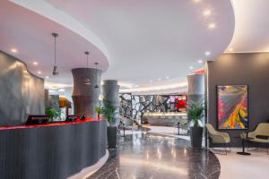 a lobby with a reception desk and a painting at UNAHOTELS Malpensa in Cerro Maggiore