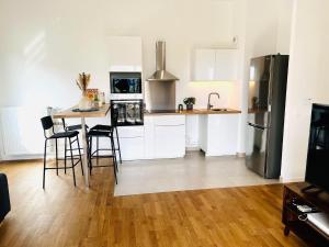a kitchen with a table with chairs and a refrigerator at Cosy chez FIFI in Chessy