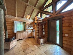 a kitchen in a log cabin with a vaulted ceiling at Căsuța din pădure in Piatra Neamţ