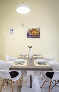 a dining room with a wooden table and white chairs at Deluxe apartman Egle1 i studio Egle 2 in Zagreb