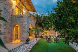 a garden with chairs and a table in front of a building at Nikolas country villa-anesis family in Kamilari