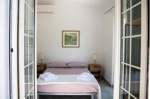 a bedroom with a bed and two mirrors at Green Villa Aegina in Aegenitissa