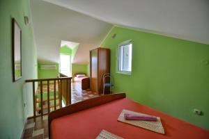 a bedroom with green walls and a red bed at Apartments Goran in Kotor