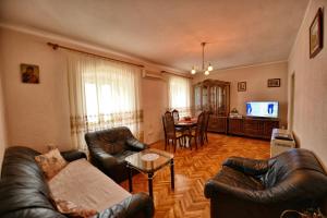 a living room with leather furniture and a dining room at Apartments Goran in Kotor