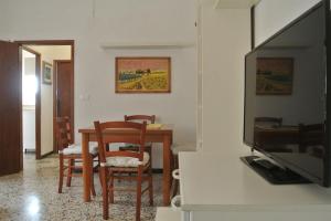 ein Wohnzimmer mit einem Esstisch und einem TV in der Unterkunft Casa Lino in Volterra