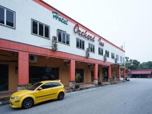 Hotel Orchard Inn في لوموت: سيارة صفراء متوقفة أمام مبنى