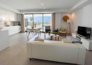 a living room with a white couch and a kitchen at Sealine Vidorra in Torrox Costa