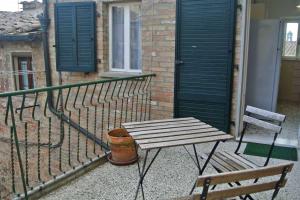 einen Holztisch und einen Stuhl auf dem Balkon in der Unterkunft Casa Lino in Volterra