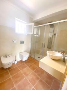 a bathroom with a toilet and a sink and a shower at Villa urbana con Piscina en Playa den Bossa in Ibiza Town
