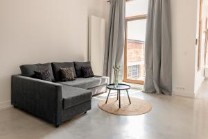 a living room with a couch and a table at Luxury Suite South in Antwerp