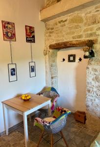 een tafel en stoelen in een kamer met een stenen muur bij Lucky Home - Apartment Art Grožnjan in Grožnjan
