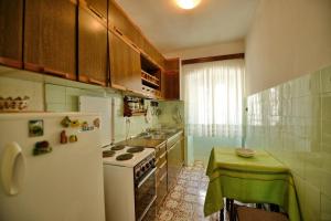 a kitchen with a white refrigerator and a table in it at Apartments Goran in Kotor