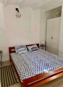 een slaapkamer met een groot bed met 2 kussens bij Lucky Home - Apartment Art Grožnjan in Grožnjan