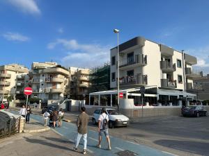 a group of people crossing a street in a city at Sul mare in Trani