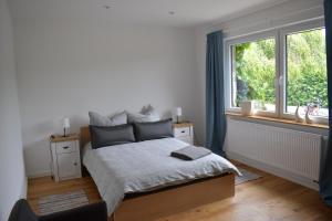 een witte slaapkamer met een bed en een raam bij Ferienwohnung Storchennest in Bad Rothenfelde