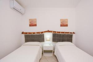 a bedroom with two beds and a nightstand between them at Appartamento della Sughereta in Budoni