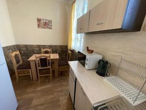 a kitchen with a counter and a table with chairs at Guest House Dobrudzha in Gabrovo