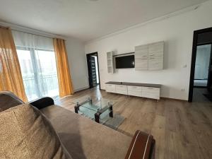 a living room with a couch and a flat screen tv at Dacia Apartments in Sebeş