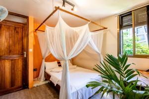 a bedroom with a bed with a mosquito net at The Slow Leopard in Dar es Salaam