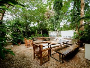 a group of picnic tables and benches in a garden at The Slow Leopard in Dar es Salaam
