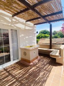 a patio with a jacuzzi tub and a bench at Villa urbana con Piscina en Playa den Bossa in Ibiza Town