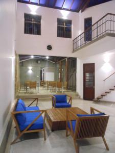 a living room with blue chairs and a table at Isana Beach House in Tangalle