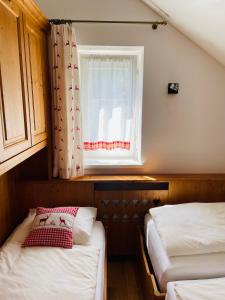 two beds in a small room with a window at Haus Jomeity in Sillian