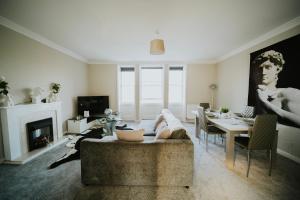sala de estar con sofá y mesa en Roman Penthouse- Skyline Views, 4K TVs, Offsite Parking, 5G WIFI and more!, en Bath