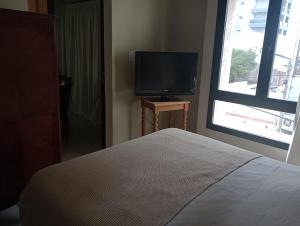a bedroom with a bed and a flat screen tv at La rue de Rox ,apart in Corrientes