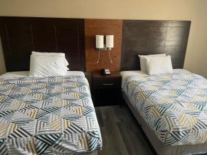 two beds sitting next to each other in a room at Motel 6 Tulsa, OK Airport in Tulsa