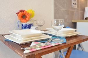 a table with plates and wine glasses on it at Sun Ray Apartments in Tivat