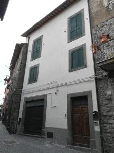 un edificio blanco con persianas verdes en una calle en A Casa di Martina, en Montefiascone