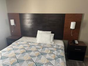a bedroom with a bed with a wooden head board at Motel 6 Tulsa, OK Airport in Tulsa