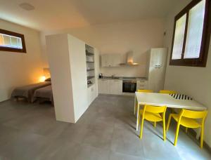 a kitchen and dining room with a table and yellow chairs at Agriturismo Oasi Bettella in Limena