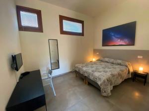 1 dormitorio con 1 cama y TV de pantalla plana en Agriturismo Oasi Bettella, en Limena