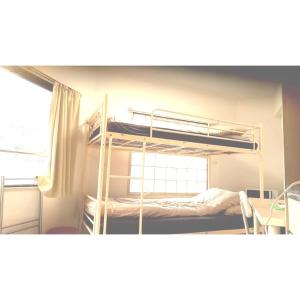 Un dormitorio con dos literas y una ventana. en Guest house Shijo K12 A202, en Kioto