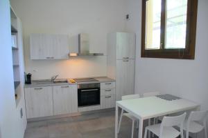 una cocina con armarios blancos y una mesa blanca con sillas. en Agriturismo Oasi Bettella, en Limena