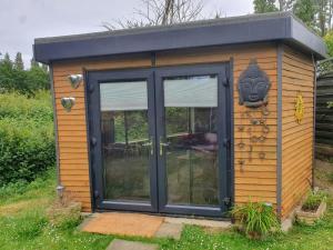 Um barracão com uma porta e um rosto. em Exclusive use of Garden Room!! em Bristol