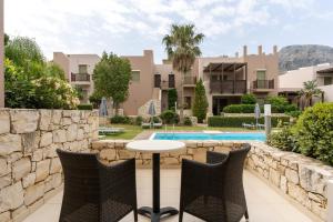 a patio with a table and chairs in front of a building at Plakias Resorts in Plakias