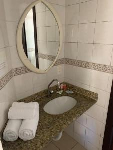 uma casa de banho com lavatório, espelho e toalhas em Pousada Bangalôs Da Mole - Florianópolis em Florianópolis