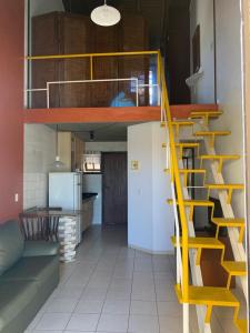 a yellow staircase in a room with a kitchen at Pousada Bangalôs Da Mole - Florianópolis in Florianópolis +65 photos