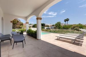 a patio with a table and chairs and a pool at Together In Salento in Morciano di Leuca