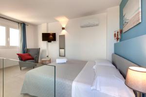 a hotel room with a bed and a chair at Together In Salento in Morciano di Leuca +142 photos