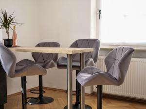a table with four gray chairs around it at PfalzZeit in Weisenheim am Berg