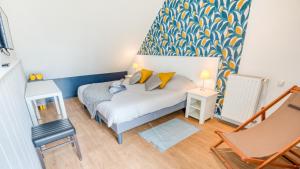 une petite chambre avec un lit et une chaise dans l'établissement Grand duplex bord de plage avec Terrasse par Groom, à Guidel 12 autres photos