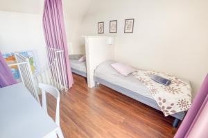 Cette petite chambre comprend 2 lits et du parquet. dans l'établissement Grand duplex bord de plage avec Terrasse par Groom, à Guidel