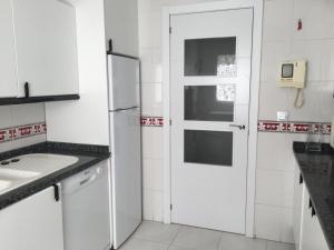 een witte keuken met een koelkast en een wastafel bij San Jacinto 69 Triana in Sevilla