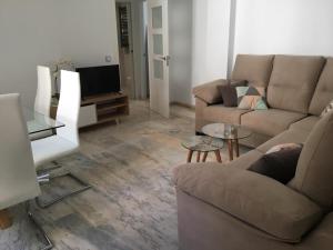 ein Wohnzimmer mit 2 Sofas und einem TV in der Unterkunft San Jacinto 69 Triana in Sevilla